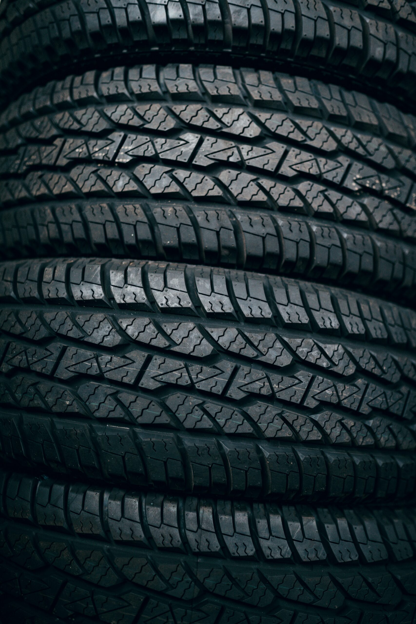 Close-up view of several tires stacked horizontally, focusing on the tread patterns.


